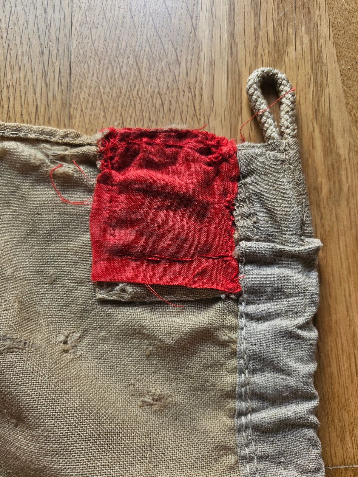 Red repair patch at upper hoist with hand stitching