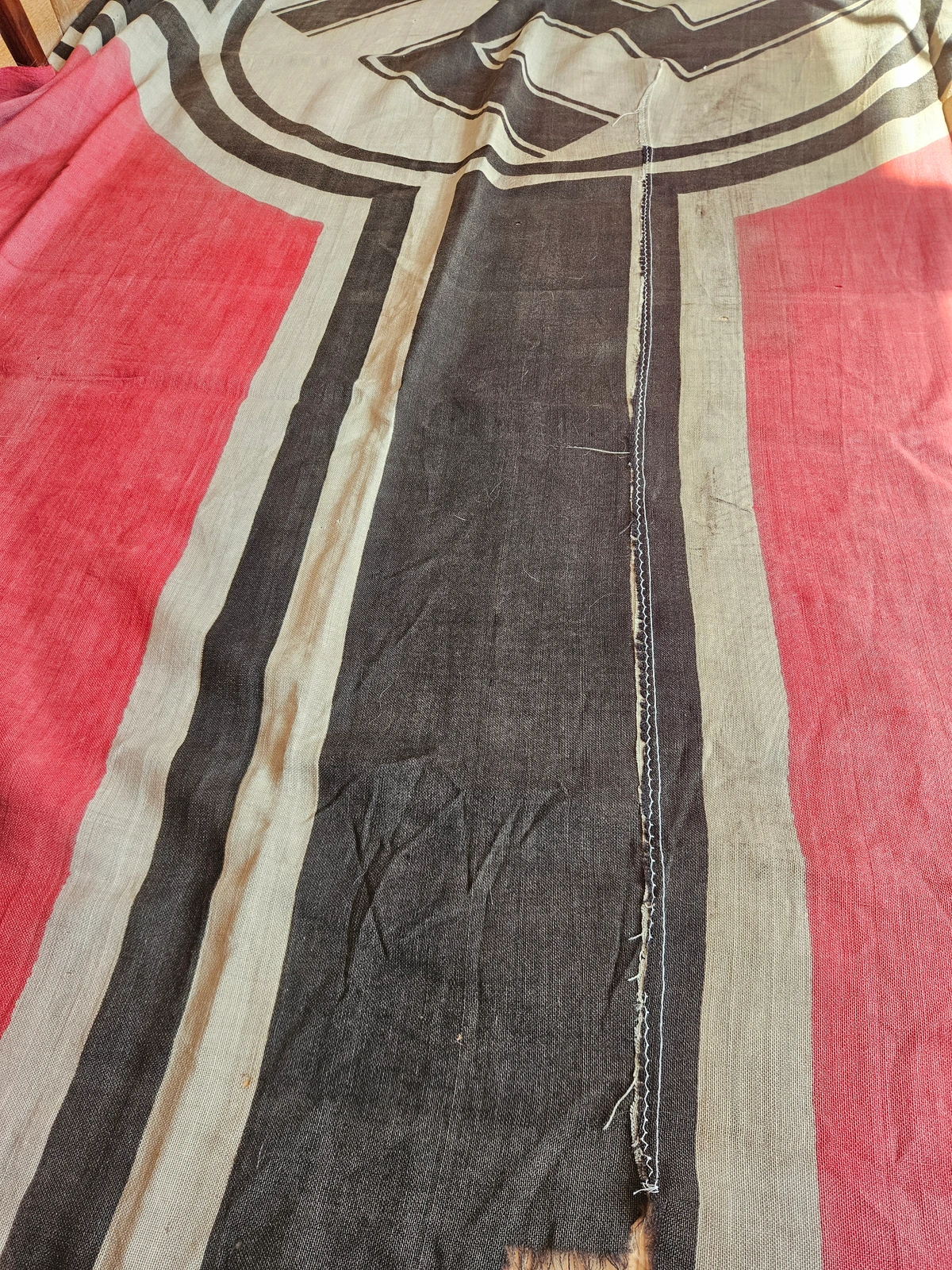 Longitudinal reconstruction seam across the black cross; staged repairs consistent with prolonged service.