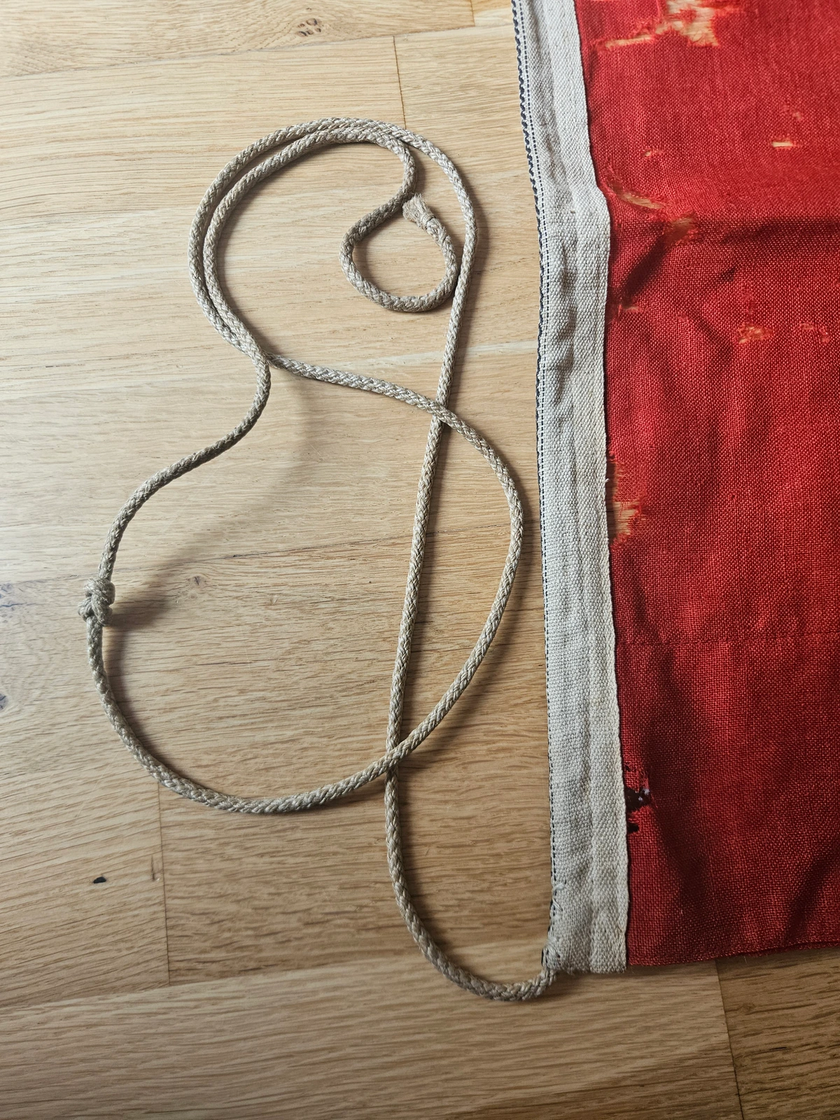 Hoist detail — grey heading, integral braided rope and wooden head-toggle; reinforcement at upper hoist.