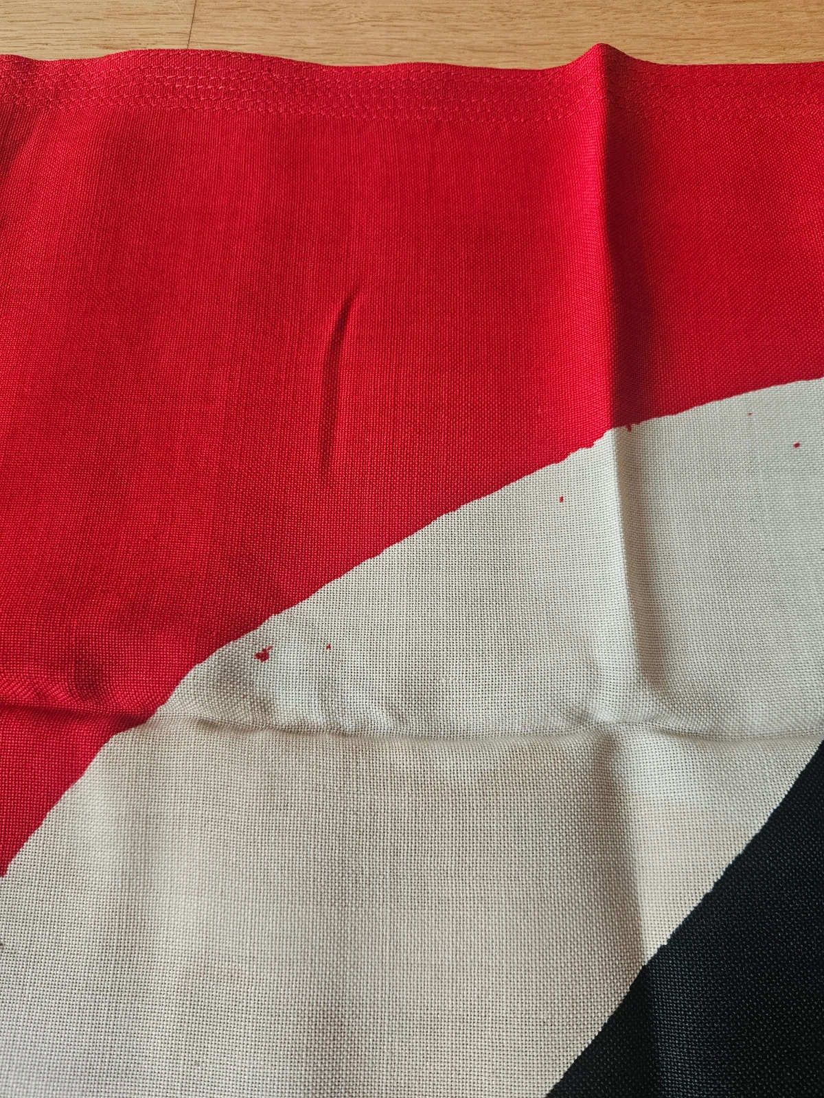 Print detail — localized red dye bleed at roundel edge.