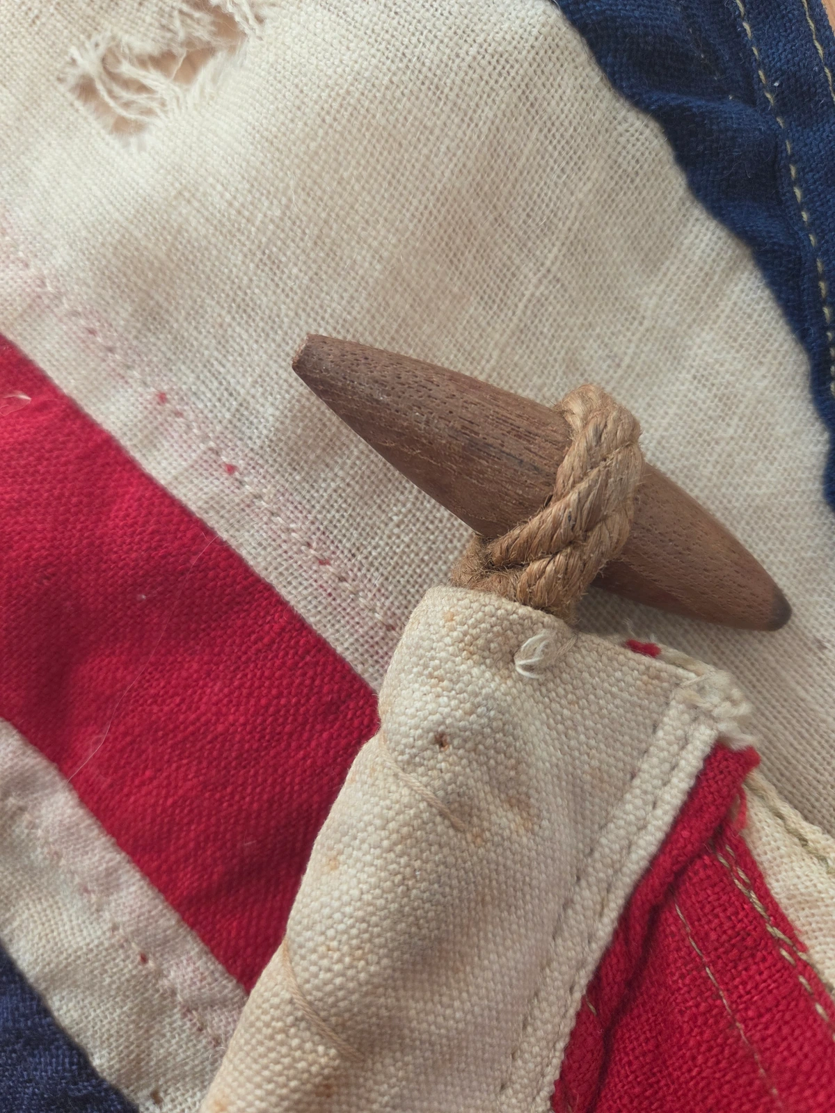 Toggle close-up: turned hardwood, period patina, hemp rope lashing