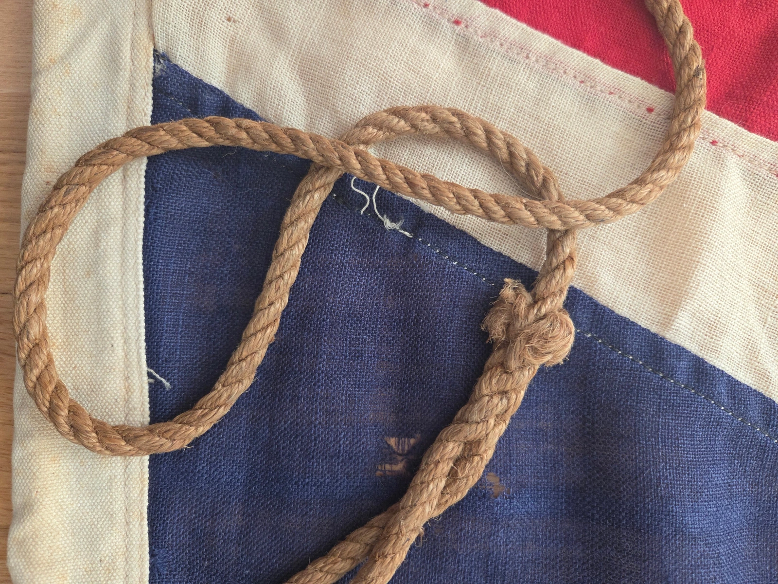 Lower hoist: hemp rope loop and knot, stitch lines along header