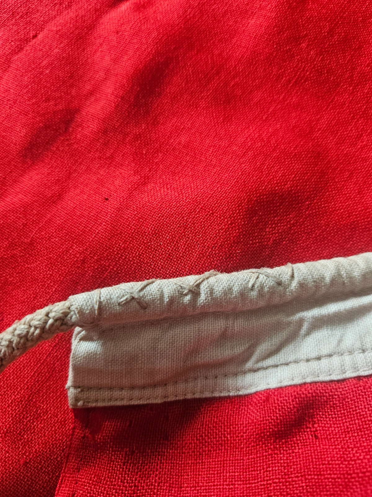 Hand-stitched reinforcement at rope exit. Strong X-stitch in natural thread through the hoist fold.