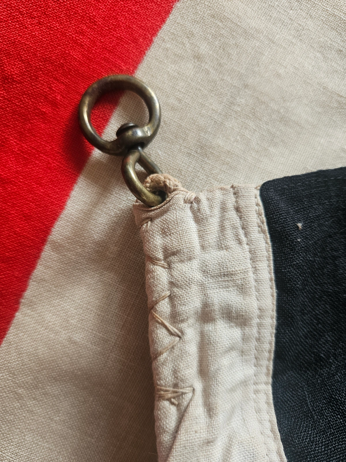 Original brass grommet mounted through thick hoist canvas. Stitching intact and historically accurate.