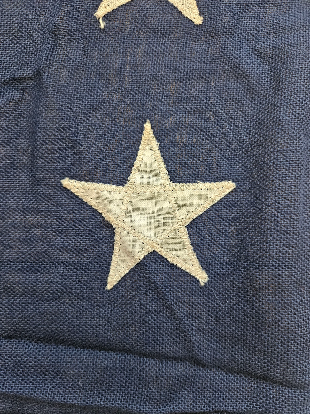 Close-up of machine-stitched appliquéd white star.