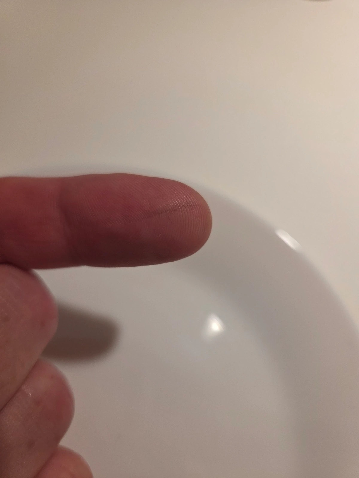 Ash rubbed to powder on fingertip after burn test